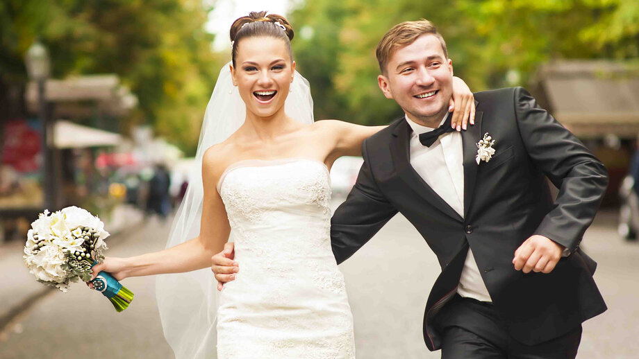 Newlyweds are walking on the street.